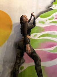 a girl posing in front of a colorful wall