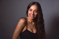 a woman in a black dress smiling for the camera
