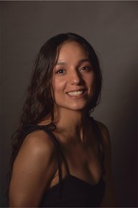 a woman in a black top smiling for the camera