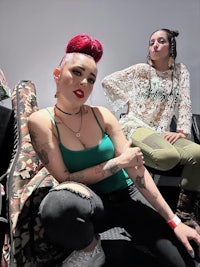 two women with tattoos and red hair posing for a photo