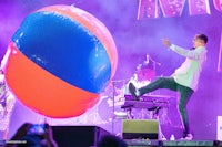 a man kicking a large ball on stage