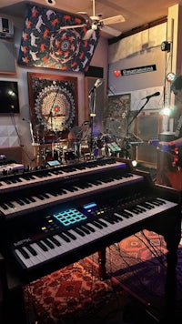 a recording studio with keyboards, drums, and other musical instruments